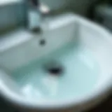 Close-up of a bathroom sink drain with standing water